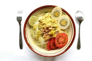soto lamongan é um prato de sopa lamongan, leste de java, indonésia. feito de frango, aletria, ovo, broto de feijão, açafrão, o caldo e koya foto