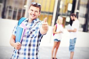 estudante bonito mostrando sinal de ok no campus foto