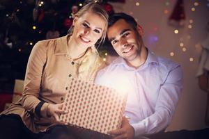 casal feliz abrindo presente de natal foto