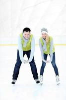 casal alegre na pista de patinação foto