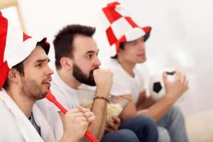 amigos do sexo masculino felizes torcendo e assistindo esportes na tv foto