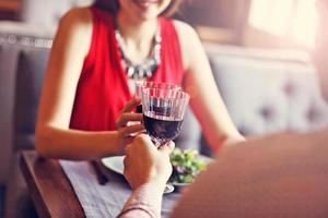 casal jantando romântico em um restaurante gourmet bebendo vinho e de mãos dadas foto