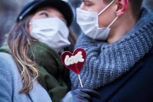 casal feliz comemorando o dia dos namorados em máscaras durante a pandemia de covid-19 foto