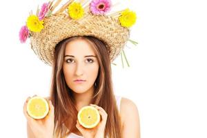 garota verão em um chapéu com flores e limões foto