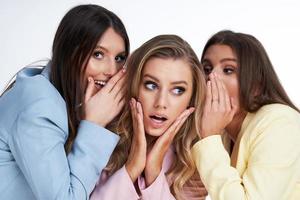 três mulheres em ternos pastel posando sobre fundo branco foto