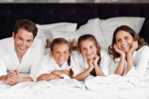 família feliz relaxando no quarto de hotel foto