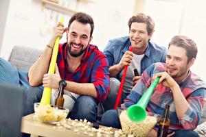 amigos do sexo masculino felizes torcendo e assistindo esportes na tv foto