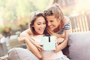 uma foto de duas amigas fazendo um presente de aniversário surpresa