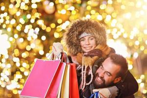 casal adulto fazendo compras na cidade durante o natal foto