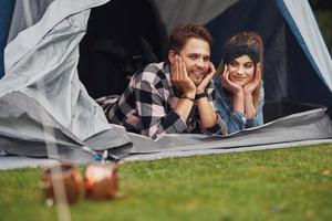 jovem casal simpático se divertindo no acampamento foto