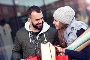 retrato de casal feliz com sacolas de compras depois de fazer compras na cidade foto