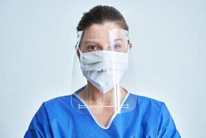 retrato de médica usando máscara protetora e escudo facial foto