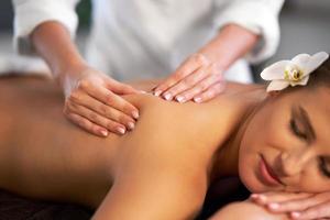 mulher relaxada recebendo massagem nas costas foto