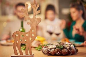 grupo de amigos rezando sobre a mesa de ação de graças de natal em casa foto