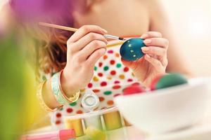 mulher atraente pintando ovos de páscoa em casa foto