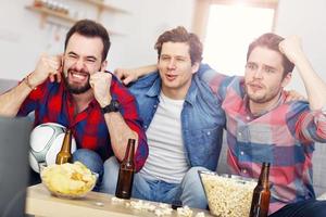 amigos do sexo masculino felizes torcendo e assistindo esportes na tv foto