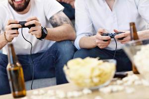 amigos se divertindo no sofá com videogames foto