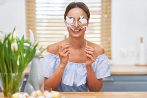 mulher adulta feliz em clima de páscoa na cozinha foto