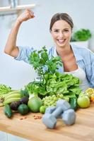 mulher adulta saudável com comida verde na cozinha