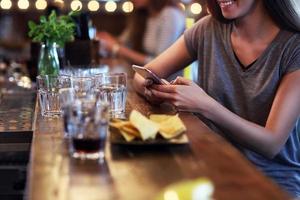 barriga de mulher mandando mensagens de texto em restaurante foto