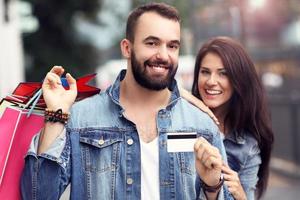 retrato de casal feliz com sacolas de compras depois de fazer compras na cidade foto