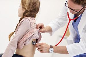 menina na clínica fazendo um check-up com pediatra foto