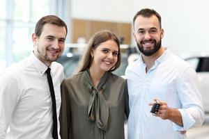 jovem casal escolhendo carro no showroom foto