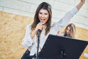 mulher caucasiana cantando no microfone no estúdio foto