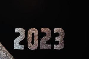 feliz ano novo 2023. números dourados em um fundo preto com glitter foto