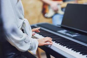 mulher caucasiana tocando teclado com banda foto