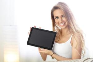 mulher feliz com tablet no sofá foto