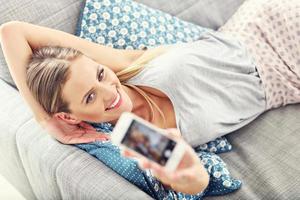 mulher feliz com smartphone em casa foto