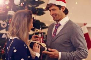 grupo de amigos com presentes de natal em casa foto