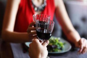 casal jantando romântico em um restaurante gourmet bebendo vinho e de mãos dadas foto