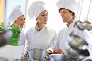 chefs ocupados trabalhando na cozinha do restaurante foto