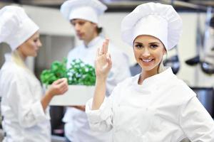 chefs ocupados trabalhando na cozinha do restaurante foto