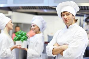 chefs ocupados trabalhando na cozinha do restaurante foto