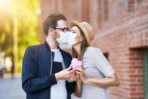 casal romântico adulto usando máscaras na caminhada na cidade foto