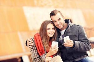 casal de outono com smartphones foto