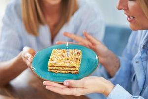 boas duas meninas adultas na casa com bolo de aniversário foto