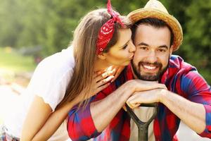 jovem casal trabalhando no jardim foto