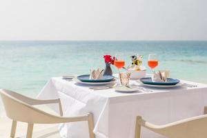 comida de café da manhã de luxo na mesa branca, com uma bela vista do mar tropical de fundo, férias de verão pela manhã e conceito de férias românticas, viagens de luxo e estilo de vida foto
