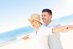 jovem casal romântico abraçados na praia foto