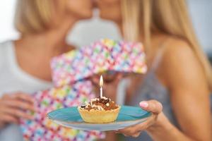 boas duas meninas adultas na casa com bolo de aniversário foto