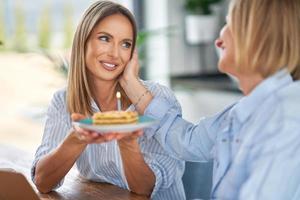 boas duas meninas adultas na casa com bolo de aniversário foto