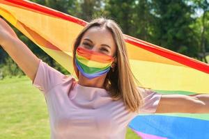 mulher vestindo bandeira lgbt ao ar livre. foto