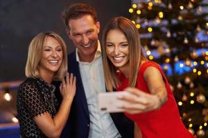 amigos de negócios comemorando a festa de natal tomando selfie foto