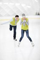 casal feliz na pista de gelo foto