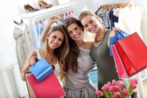 grupo de amigos felizes fazendo compras na loja foto