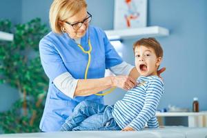 médico pediatra examinando crianças na clínica foto